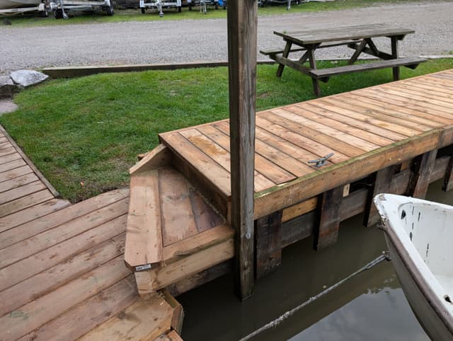 Rebuilt dock deck framed tight around the piling, with a cleat set flush at the edge — Georgian Bay, Ontario
