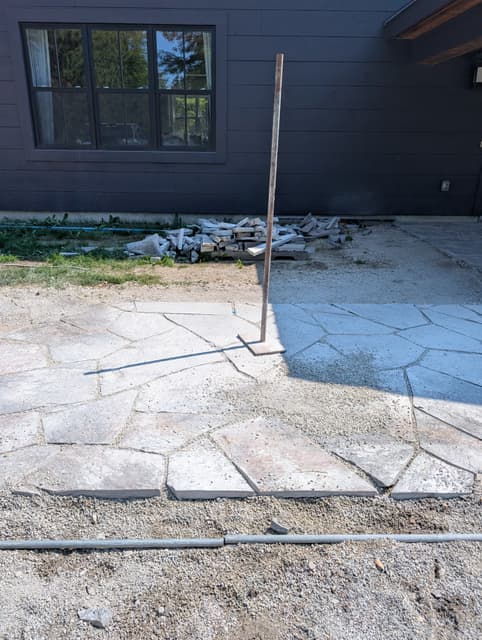 Steel screed rails set on the compacted base to run the bedding level with the laid stone. — Collingwood, Ontario