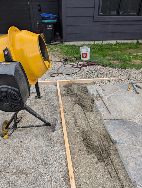 Mixer and timber screed frame set up beside the stone, bedding mix spread for the next run. — Collingwood, Ontario
