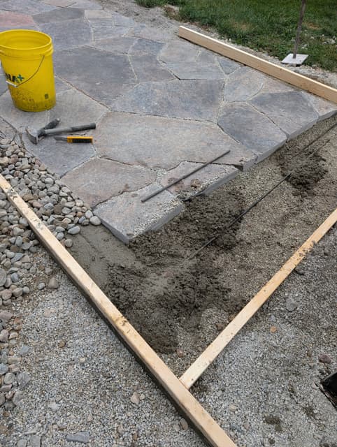 Bedding mix screeded between timber rails, ready for the next course of flagstone. — Collingwood, Ontario