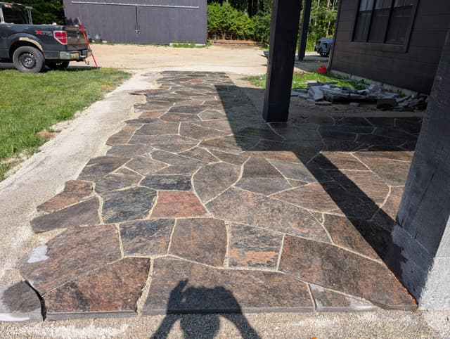 Warm granite flagstone laid tight around the porch post, joints hand-fitted. — Collingwood, Ontario