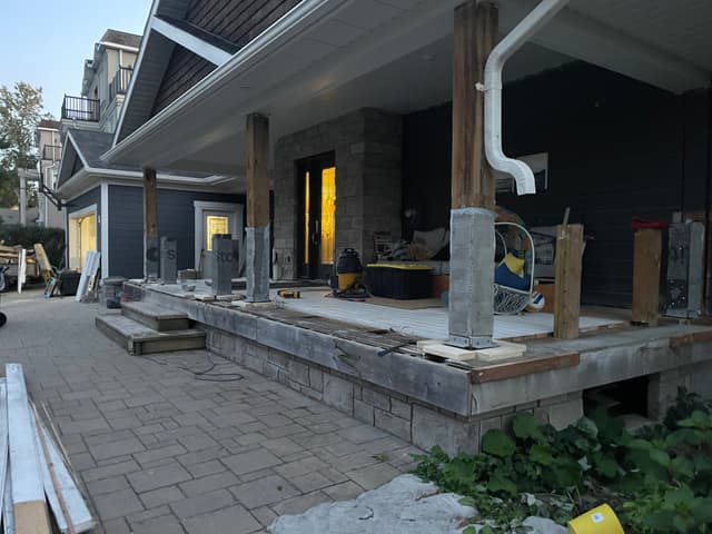 Stone facing carried along the porch skirt, with timber posts set the length of the covered front. — Georgian Bay, Ontario