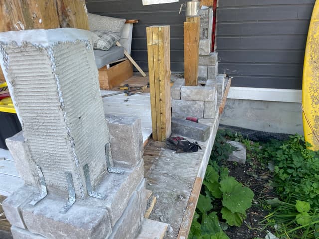 Stone veneer laid up around a column base, corner units alternated course by course over the scratch coat. — Georgian Bay, Ontario
