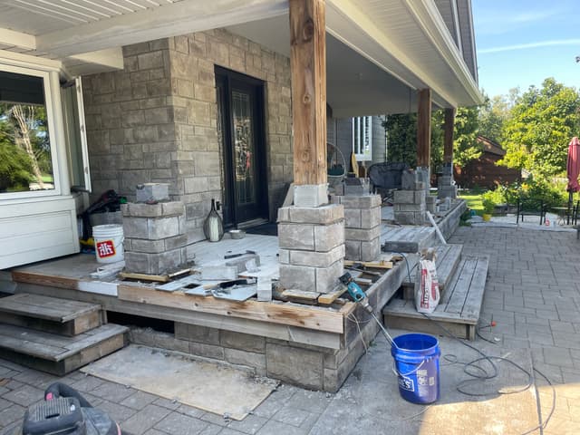 Stone column bases coursed up around the timber posts along the porch. — Georgian Bay, Ontario