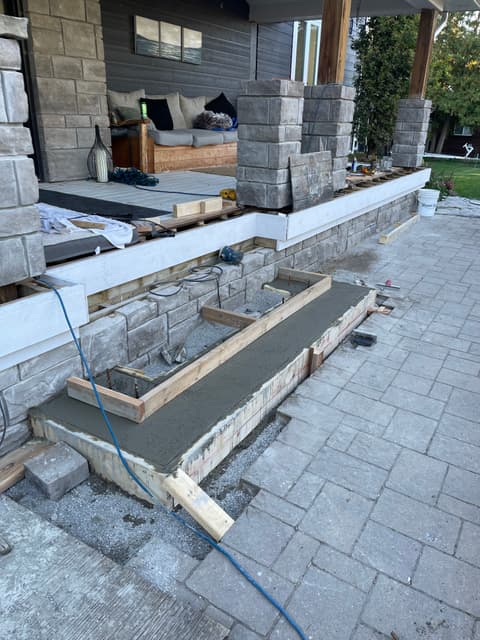Concrete step poured into site-built forms against the stone-faced porch wall. — Georgian Bay, Ontario