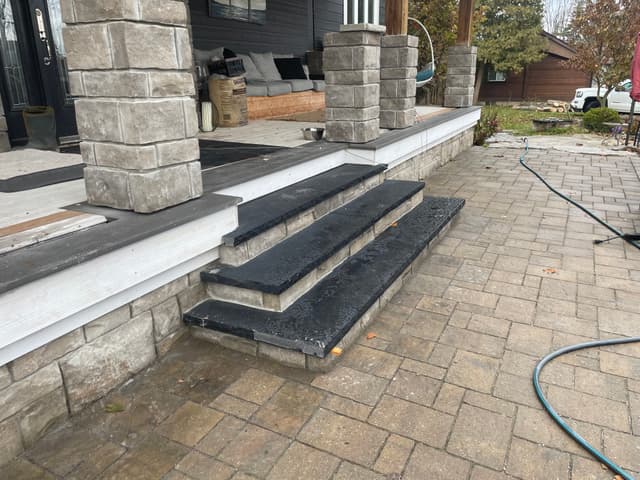 Dark stone treads capping the poured concrete steps down to the paver patio. — Georgian Bay, Ontario