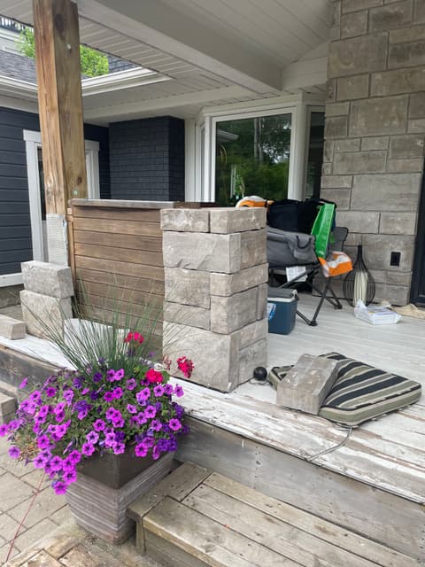 Dry-laid stone pier built up beside the wood slat privacy wall on the porch deck. — Georgian Bay, Ontario